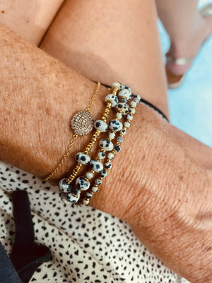 Poignet orné de bracelets en perles et en or.